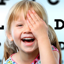 Young girl smiling during vision test.