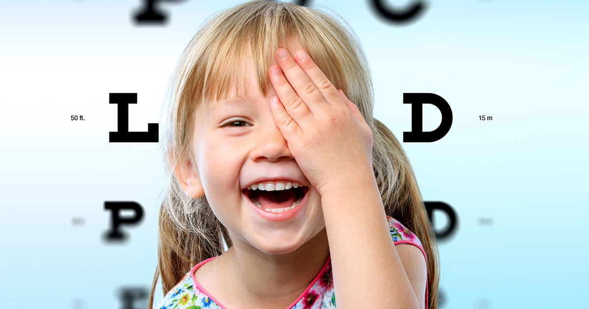 Young girl smiling during vision test.