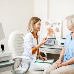 older woman taking with her eye doctor
