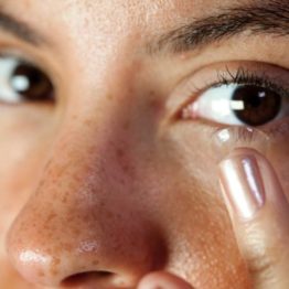 woman putting in a contact lens