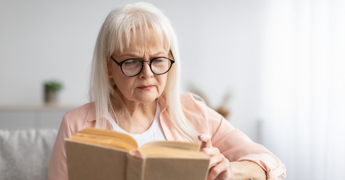 mature woman with confused face trying to read book