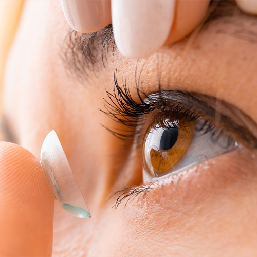Female placing contact in her eye for clearer  vision.