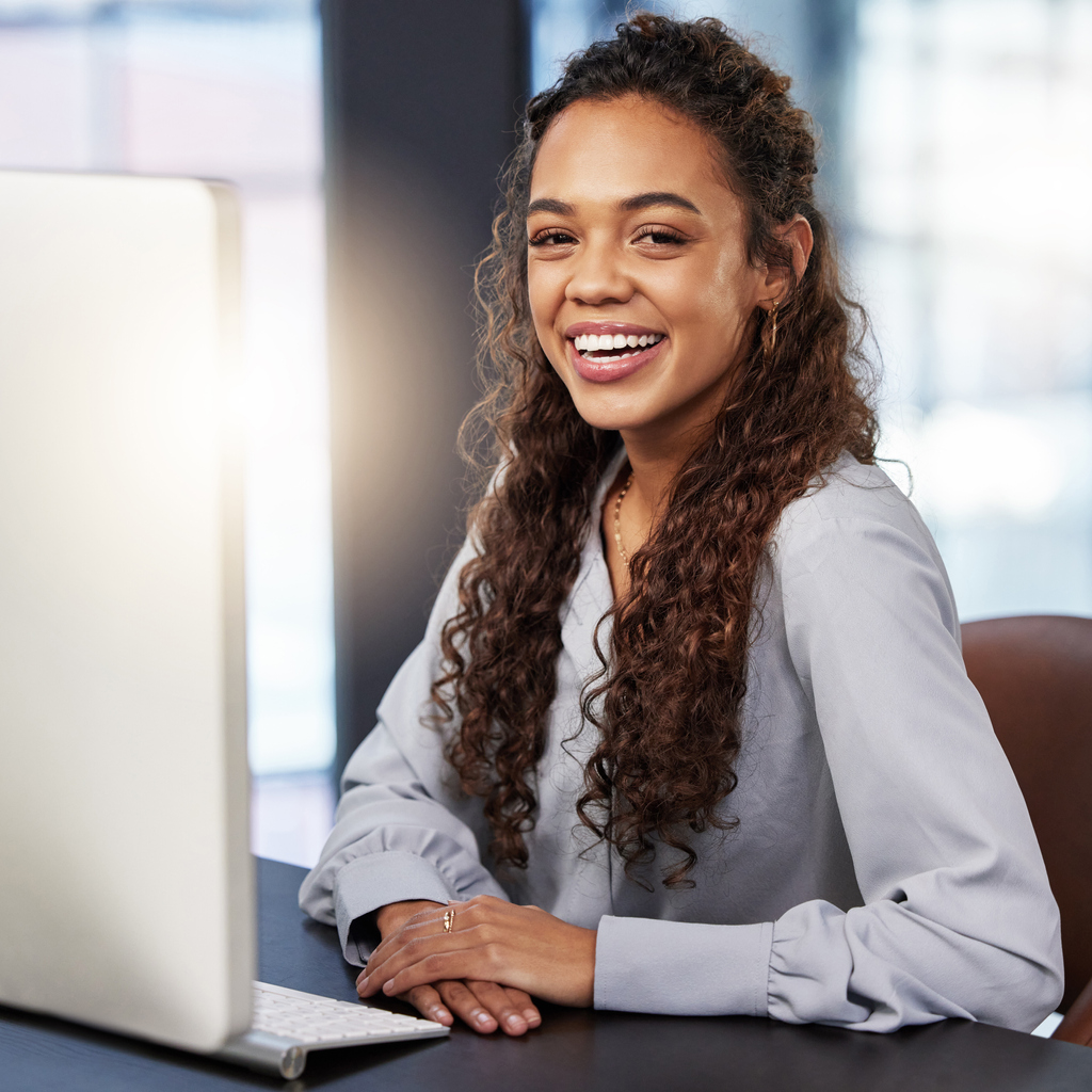 Happy Businesswoman smiling in front of computer