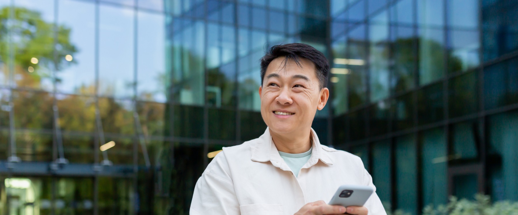 Smiling asian man holding phone
