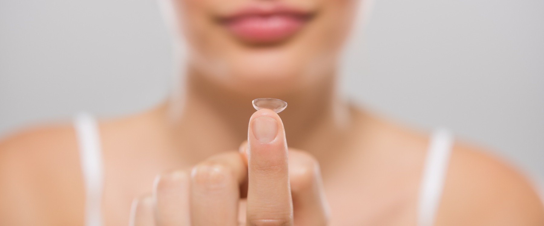 Woman holding contact lens