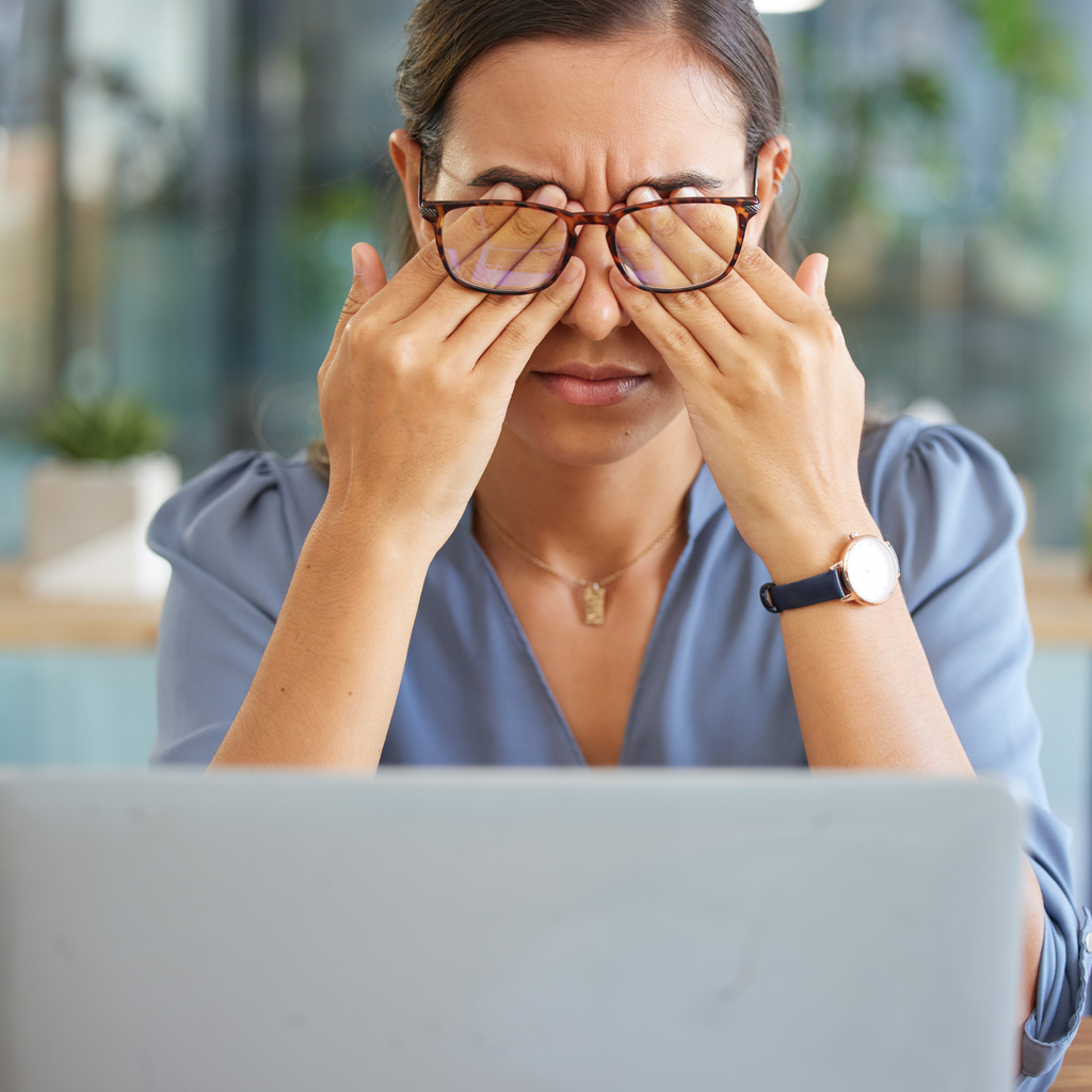 Woman with glasses rubbing eyes